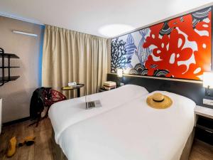 プレランにあるibis Styles Saint Brieuc Plerinのホテルルーム(大きな白いベッド、帽子付)