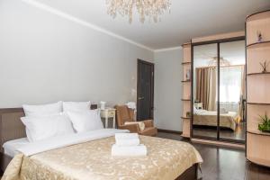 um quarto com uma grande cama branca e um lustre em Апартаменты в районе Горного воздуха em Yuzhno-Sakhalinsk