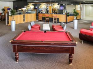 uma mesa de bilhar num quarto com cadeiras e um bar em ibis Cardiff Gate - International Business Park em Cardiff