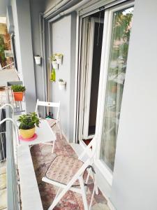 een balkon met stoelen, een tafel en een raam bij George's Old House in Thessaloniki