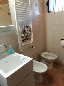 y baño con lavabo blanco y aseo. en Guado di Pio- monolocale en Il Guasto