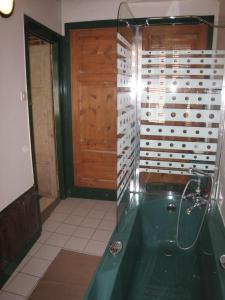 baño con bañera verde y puerta de madera en Gite de Flandre, en Cassel