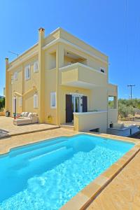 a villa with a swimming pool in front of a house at VILLA KONSTANTINOS 6 bedrooms in Egina
