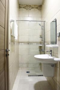 a bathroom with a sink and a shower at Roza Hotel Apartments in Muscat +25 photos
