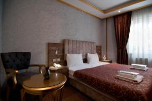 A bed or beds in a room at Grand Ambiance Hotel