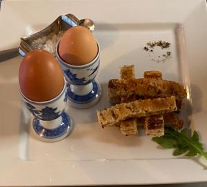 a white plate with two eggs and some food on it at The White House Hotel in Newquay