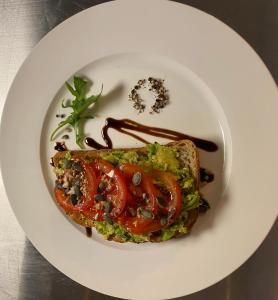 a white plate with a piece of bread with tomatoes andetchup at The White House Hotel in Newquay