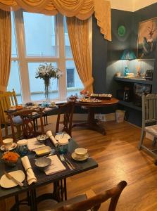 a dining room with a table and chairs and a room with a window at The White House Hotel in Newquay