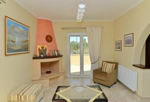 a living room with a fireplace and a chair at VILLA KONSTANTINOS 6 bedrooms in Egina