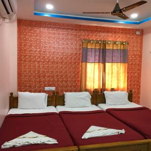 two beds sitting next to each other in a room at Jayaram Residency Srikalahasti in Srikalahasti