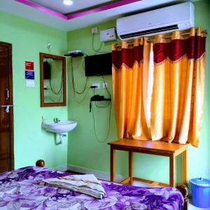 a hospital room with a bed and a sink at Jayaram Residency Tirupathi in Tirupati