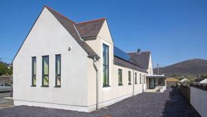 a white building with a brown roof at Canolfan Y Fron in Caernarfon