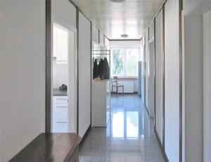 a hallway of a kitchen with white walls and a long floor at Churfirsten Blick - Private Gästezimmer in Flums