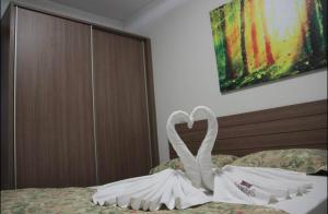a swan made out of towels sitting on a bed at FLAT VEREDAS RIO QUENTE Apto 113 in Rio Quente