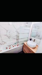 Cosy Appart Hotel Boulogne -Paris في بولون بيانكور: حمام مع حوض أبيض ومغسلة وحوض استحمام