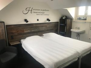 a bedroom with a white bed and a sink at 't Reijmerhöfke in Reijmerstok