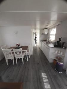 a kitchen and dining room with a table and chairs at Bospareltjes Luxe chalets Alleen voor recreatie in Oisterwijk