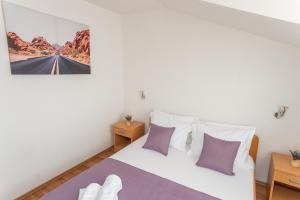 a bedroom with a bed with purple and white pillows at Villa Verbena in Mala Čista +63 photos