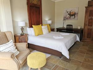 a bedroom with a bed and a couch and a chair at Excellent Guest House in Bellville