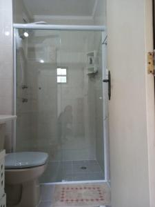 y baño con ducha y aseo. en Apto Condominio Wembley Tenis, en Ubatuba