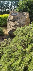 un cartel en una roca en un jardín en Hotel Mediterraneo, en Qualiano