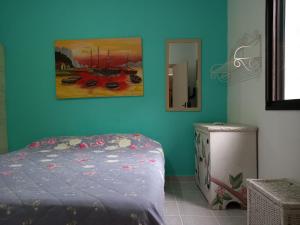 1 dormitorio con 1 cama y una pintura en la pared en Apto Condominio Wembley Tenis, en Ubatuba