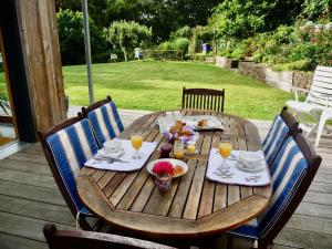 un tavolo in legno con cibo e bevande su un patio di La Miellerie a Lannion