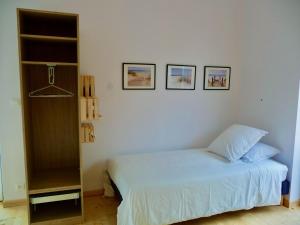 a bedroom with a bed and three pictures on the wall at La Miellerie in Lannion