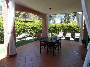 eine Terrasse mit einem Tisch und Stühlen auf einer Veranda in der Unterkunft Apartment Villa Luna in Magazzini