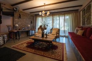 sala de estar con sofá rojo y mesa en Vathyskia Guesthouse en Kato Trikala Korinthias