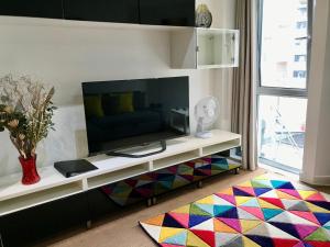 a living room with a television and a colorful rug at Marsh House in Bristol