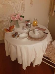 einen Tisch mit einem weißen Tischtuch und Blumen darauf in der Unterkunft Chez Martine in Hanc