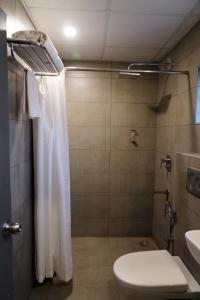 a bathroom with a toilet and a shower and a sink at Hotel Bakya Slot - Maraimalai Nagar in Chengalpattu