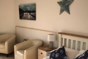 a room with a chair and a starfish on the wall at Seaside Studio right on the coastal path. in West Bay