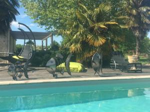 a metal sculpture of fish next to a swimming pool at Gîtes By Medoc in Bégadan