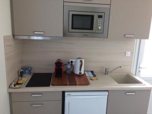 a small kitchen with a sink and a microwave at La parenthèse in Saintes