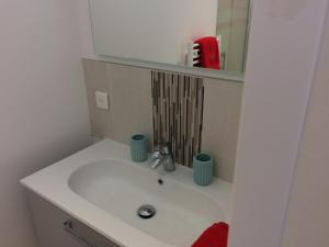 La salle de bains est pourvue d'un lavabo blanc et d'un miroir. dans l'établissement La parenthèse, à Saintes