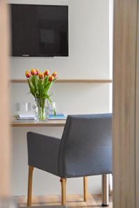 une table avec un vase de fleurs et une chaise dans l'établissement Gasthof Krone Hotel & Restaurant, à Friedrichshafen