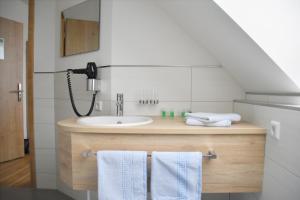 uma casa de banho com um lavatório e um telefone em Gasthof Krone Hotel & Restaurant em Friedrichshafen