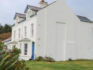 a large white building with a blue door at Carriguisnagh in Ballycastle