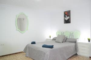 ein weißes Schlafzimmer mit einem Bett und einem Spiegel in der Unterkunft Gran Notch in Alicante