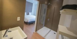 ein Bad mit einer Dusche neben einem Waschbecken und einem WC in der Unterkunft Villa Fluisterbos in Ostende
