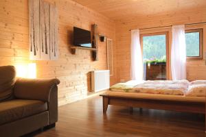 um quarto com uma cama, um sofá e uma janela em Pension Lichtspitze em Häselgehr