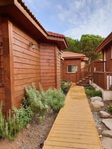 a wooden walkway leading to a house at BeLev Odem in Odem