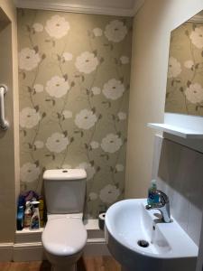 La salle de bains est pourvue de toilettes blanches et d'un lavabo. dans l'établissement Grange House Bed & Breakfast, à Lowdham