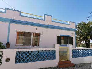a white house with blue trim and a fence at Casa do Lado in Carrapateira