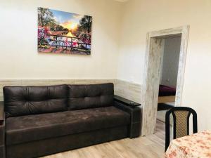 a couch in a living room with a painting on the wall at Шевченко двор in Kropyvnytskyi