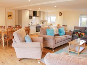 a living room with two couches and a kitchen at Conkers' Cottage in Church Stretton