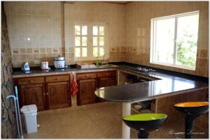 uma cozinha com armários de madeira e uma bancada em Exotic Guest House em Praslin