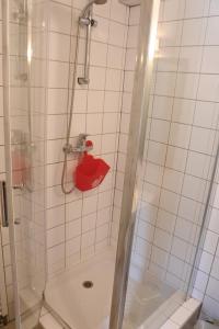 una doccia con secchio rosso in bagno di La Légende des 2 Pierres a Eguisheim